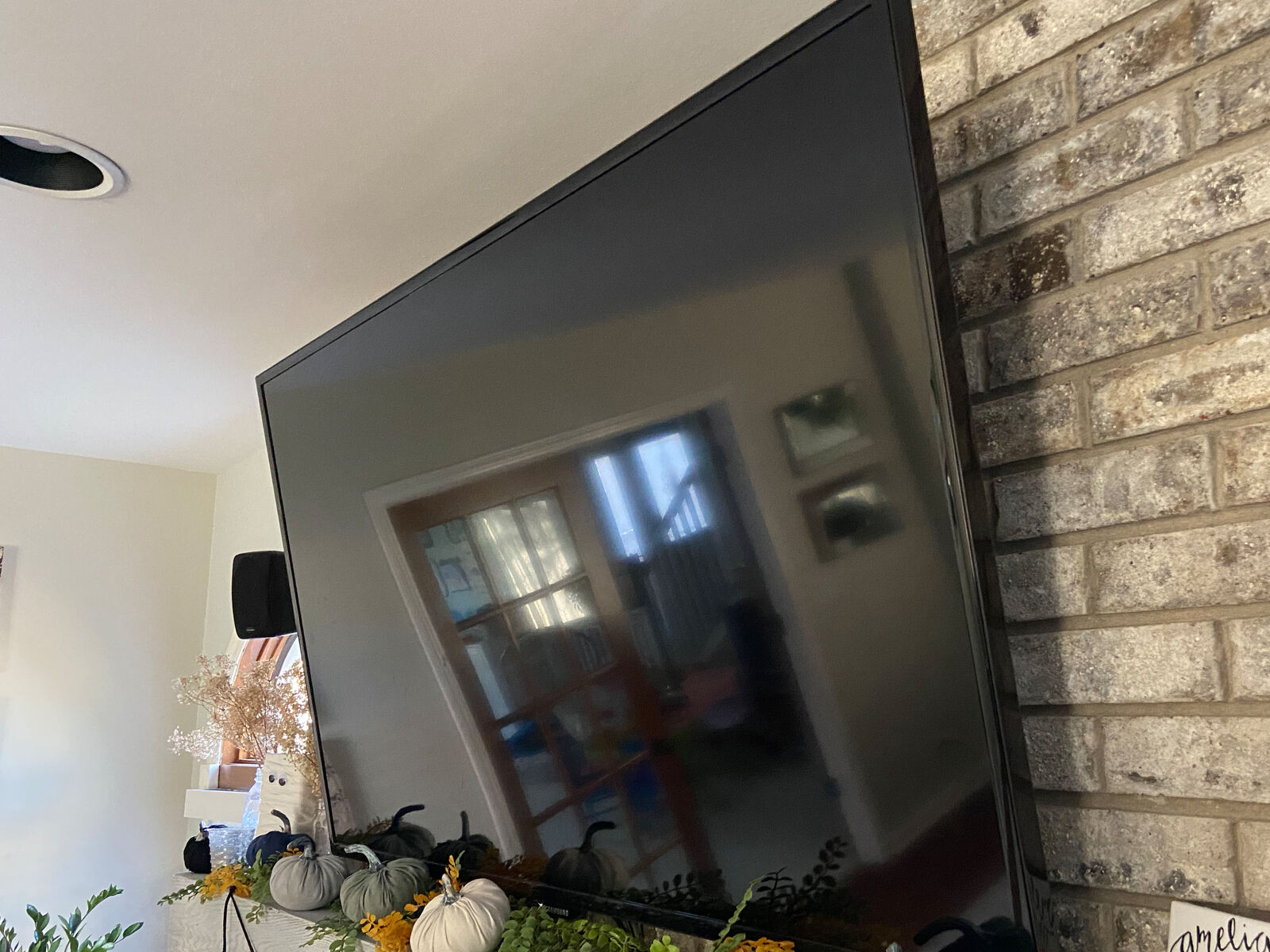 TV mounted to masonry above a fireplace